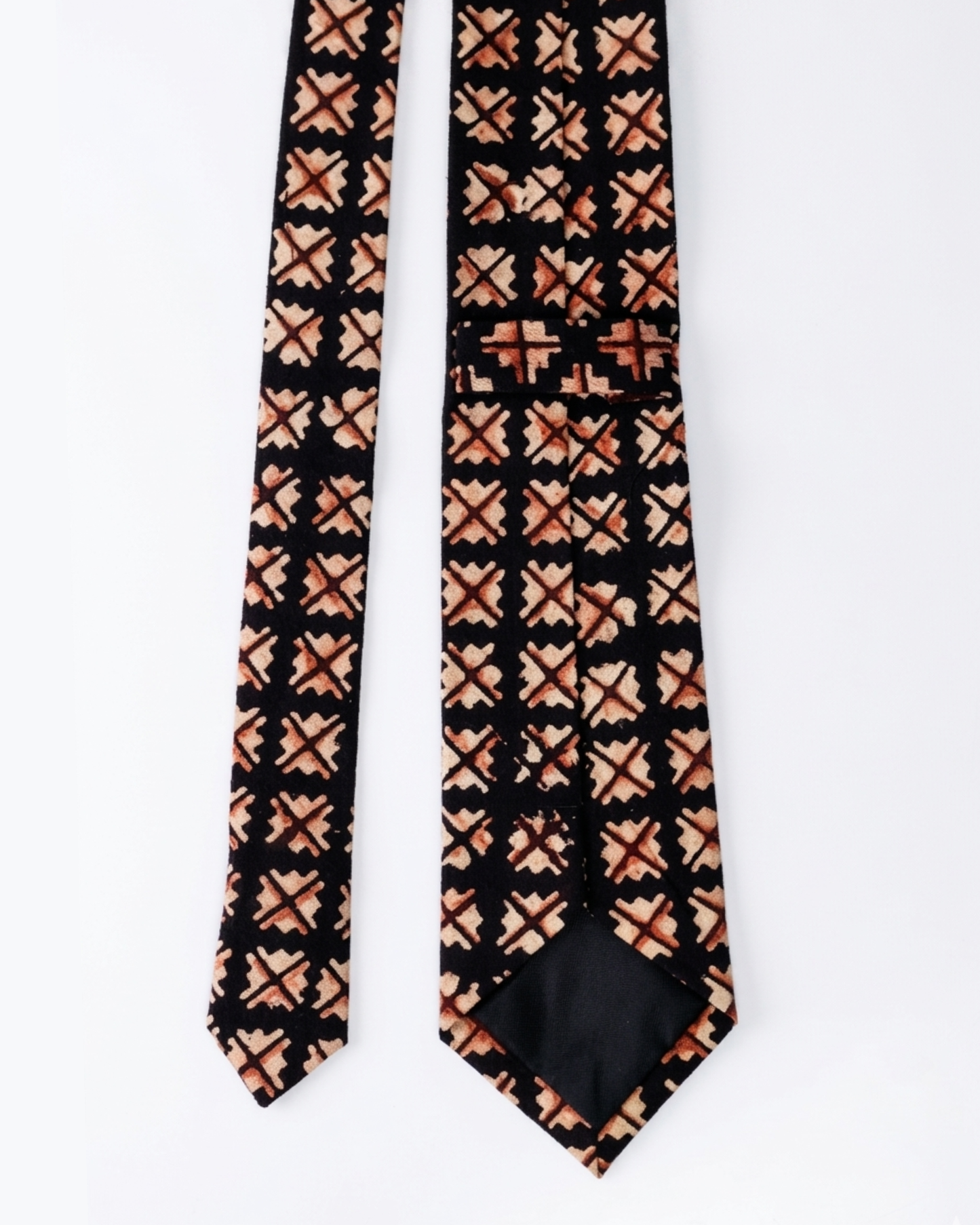 Natural dye hand block print cotton tie with near black base and sand camel burnt rust geometric cross diamond motifs handcrafted in Sindh Pakistan