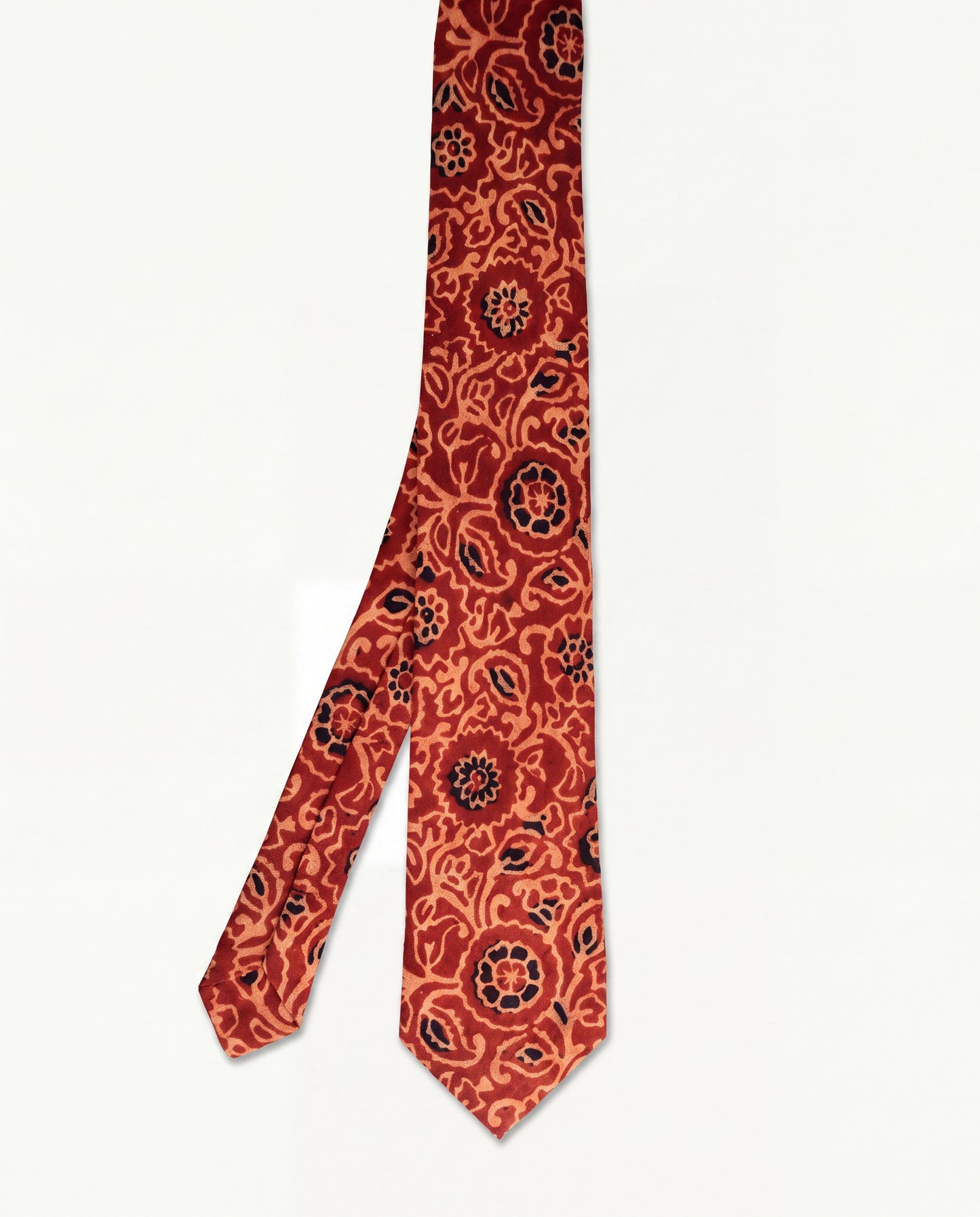 Handcrafted natural dye block print silk necktie in rust and terracotta floral pattern made from premium silk, displayed for luxury men's fashion.