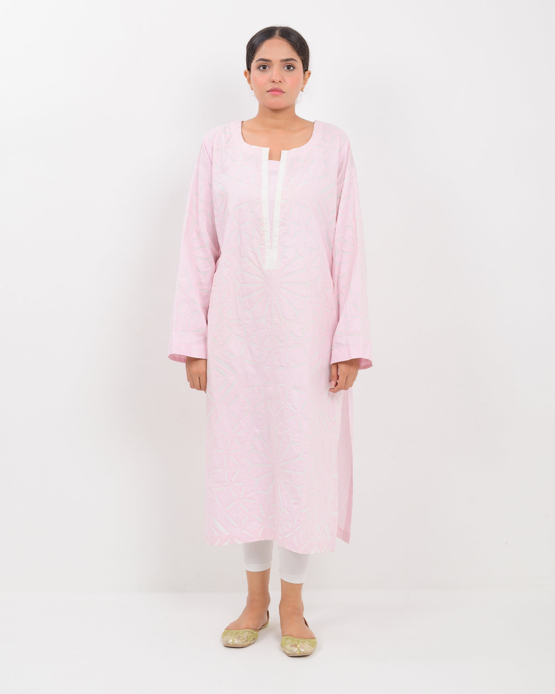A woman wearing a light pink Applique cutwork Shirt with a white pants on a white background