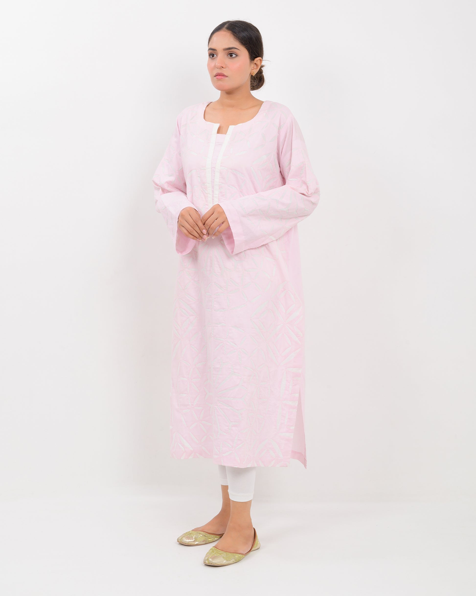 A woman wearing a light pink Applique cutwork Shirt with a white pants on a white background