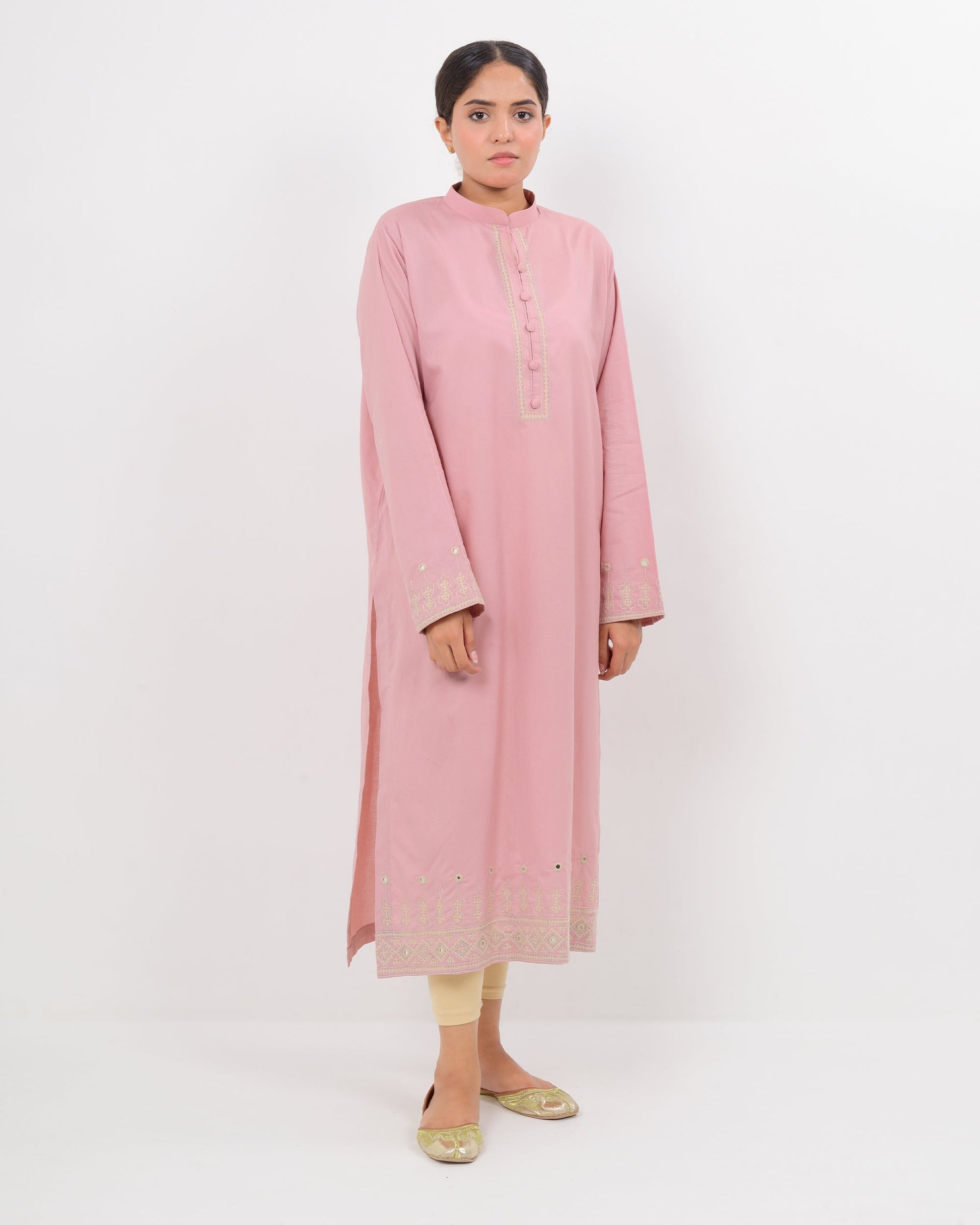 Woman wearing a pink Hurmich craft mirror work  shirt with a white background