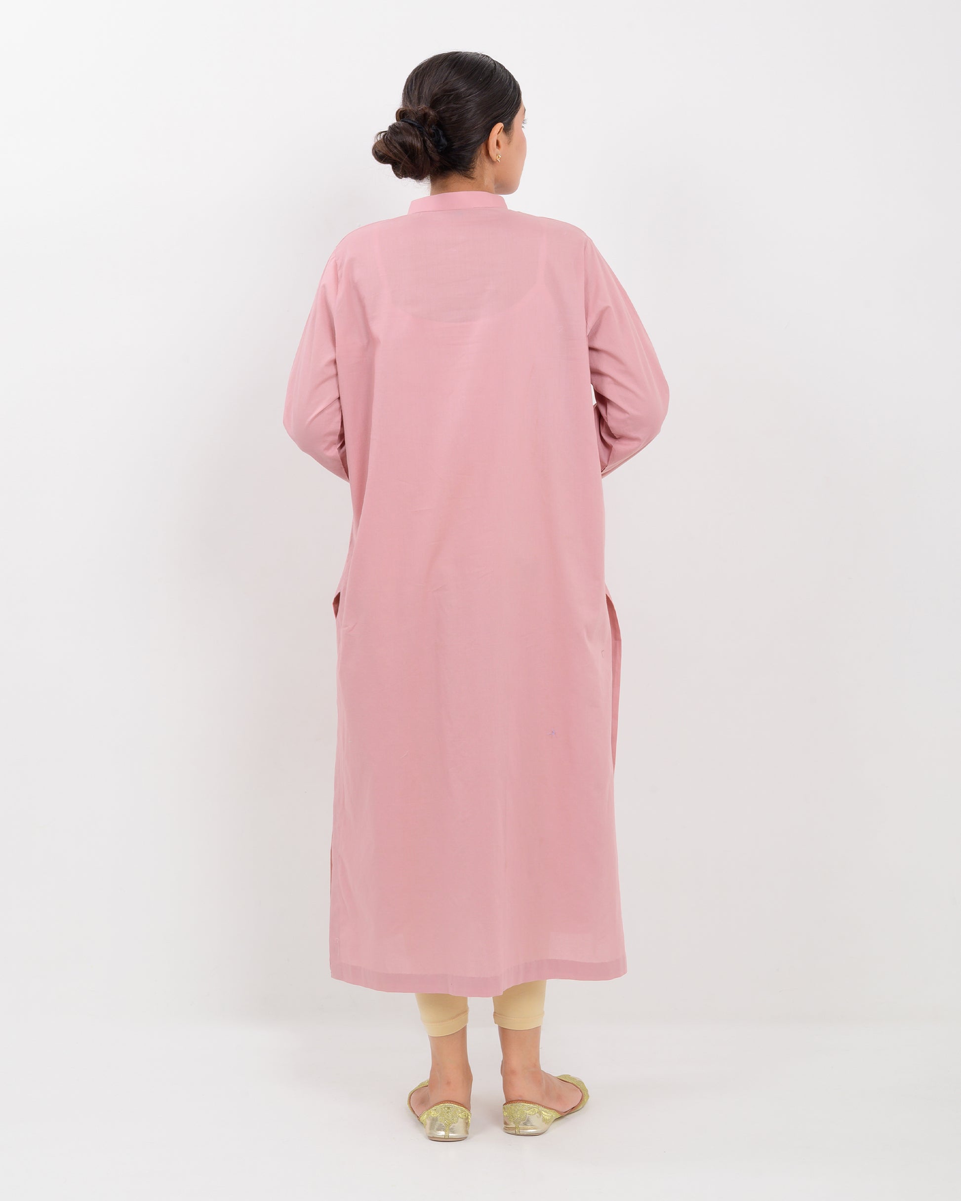 Woman wearing a pink Hurmich craft mirror work  shirt with a white background