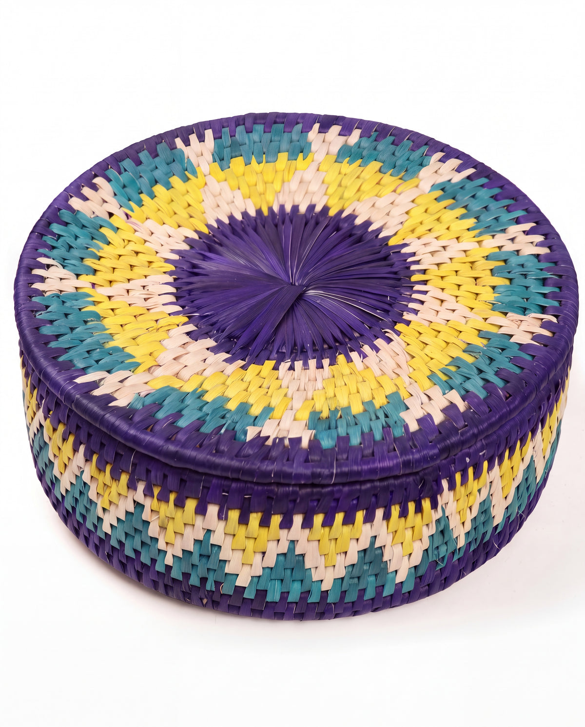 A round woven basket with a lid, featuring a geometric pattern in purple, yellow, teal, and cream on a white background.
