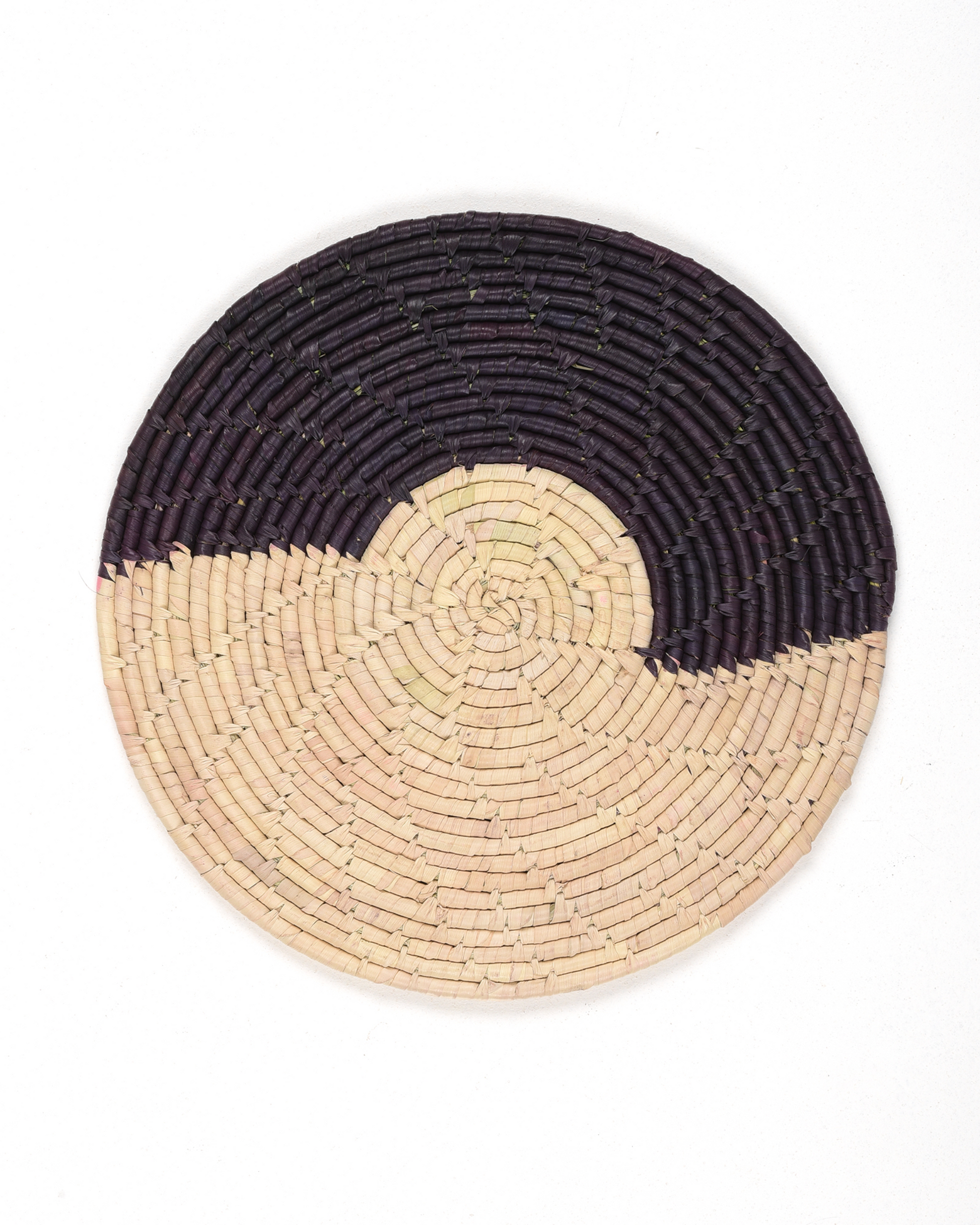 Round woven placemat with black and beige design on a white background