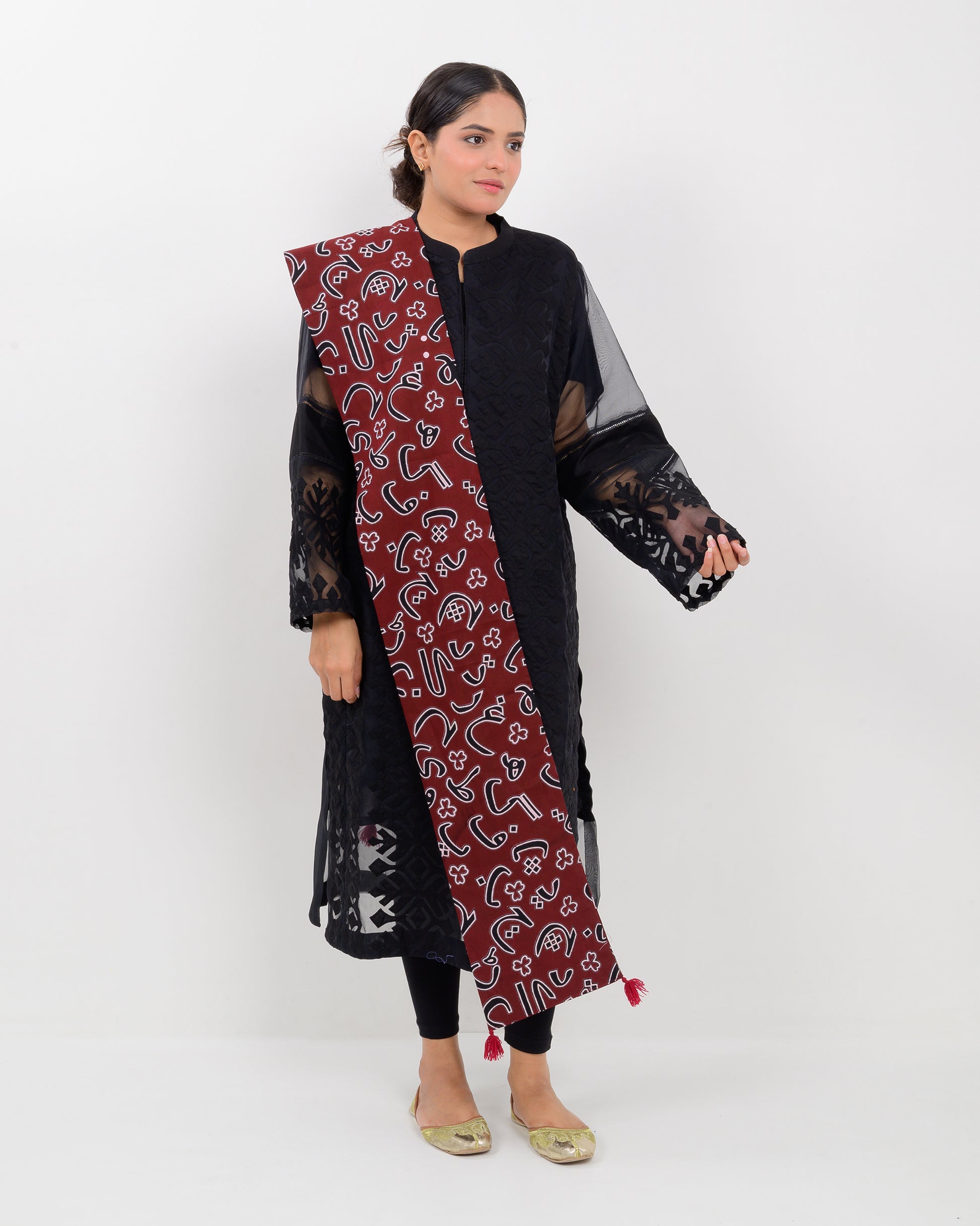 A woman wearing a black outfit with a Red color Sindhi script, stole on a white background.