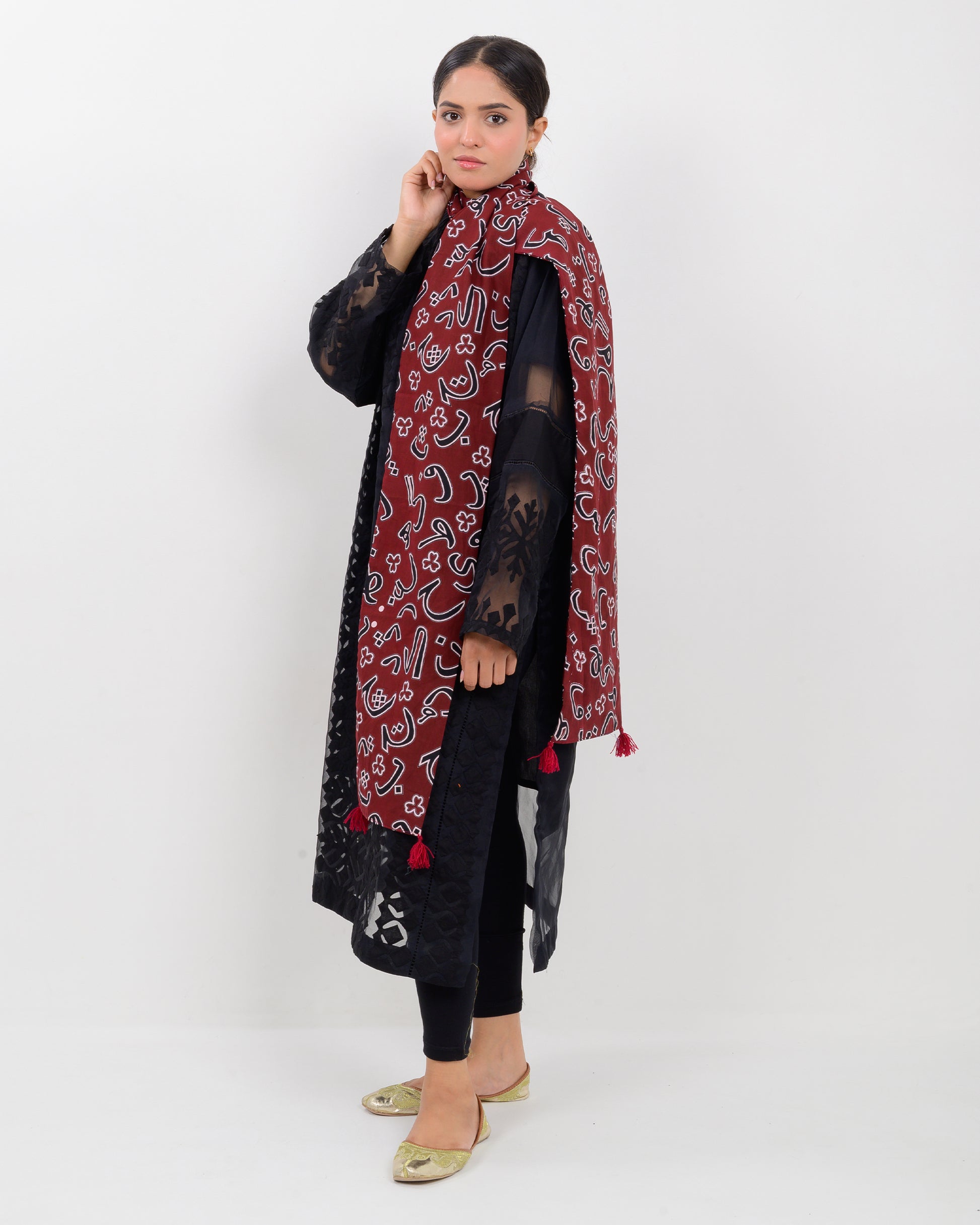 A woman wearing a black outfit with a Red color Sindhi script, stole on a white background.