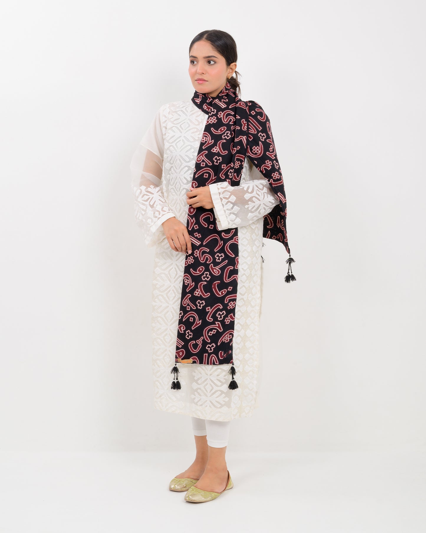 A woman wearing a black outfit with a Black color Sindhi script, stole on a white background.