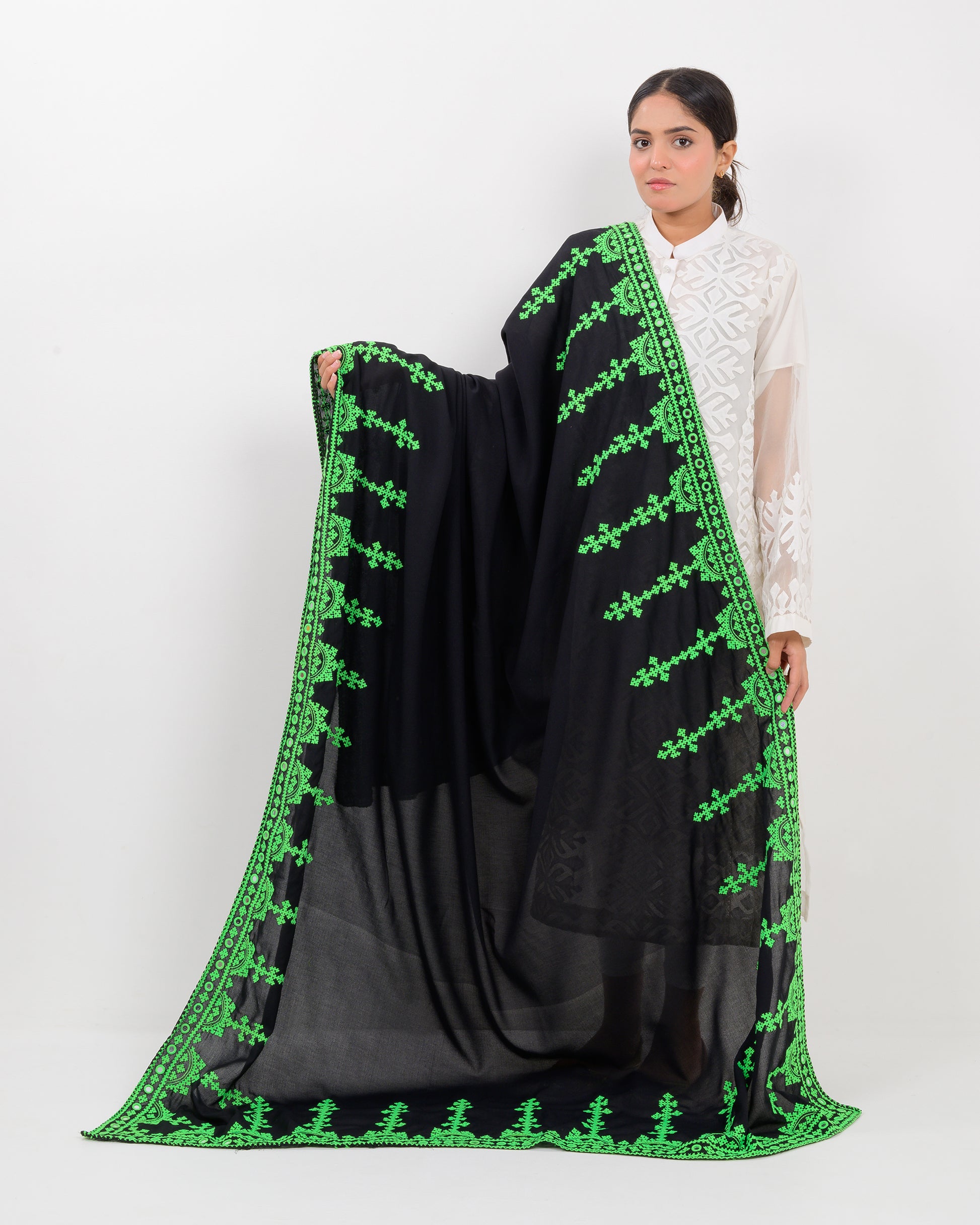 Woman wearing a black color with green hurmich embroidery shawl on a white background