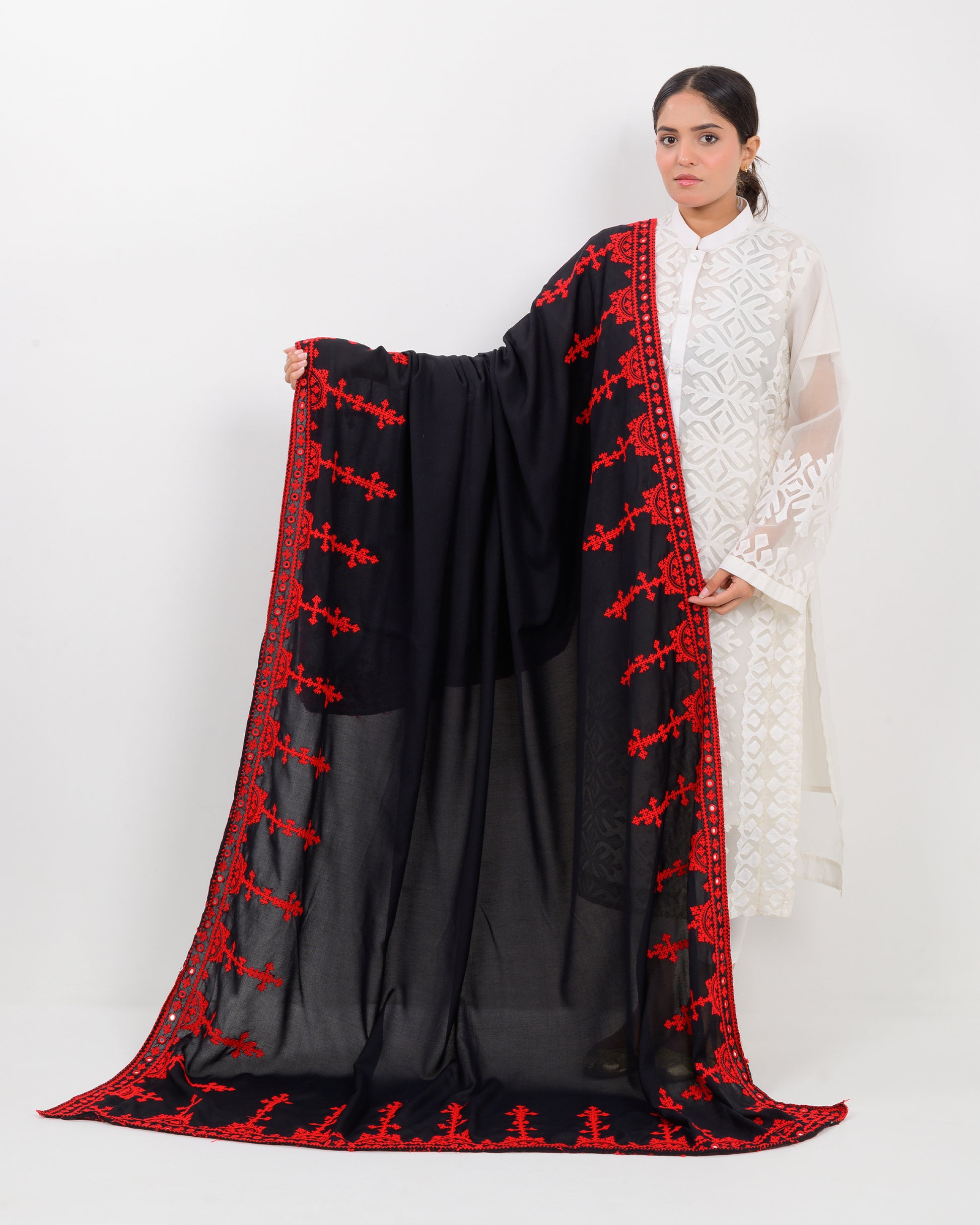 Woman wearing a black color with red hurmich embroidery shawl on a white background