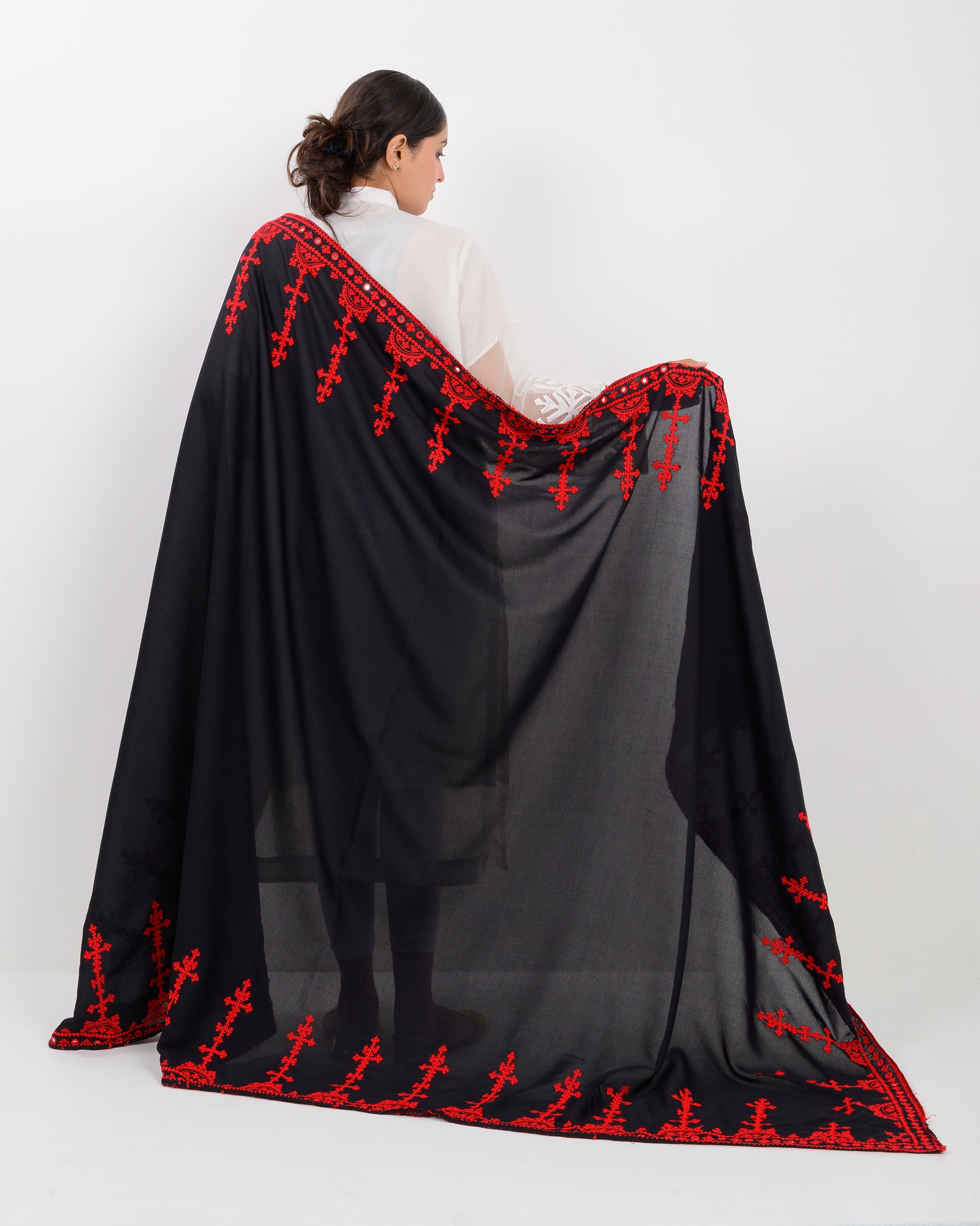 Woman wearing a black color with red hurmich embroidery shawl on a white background